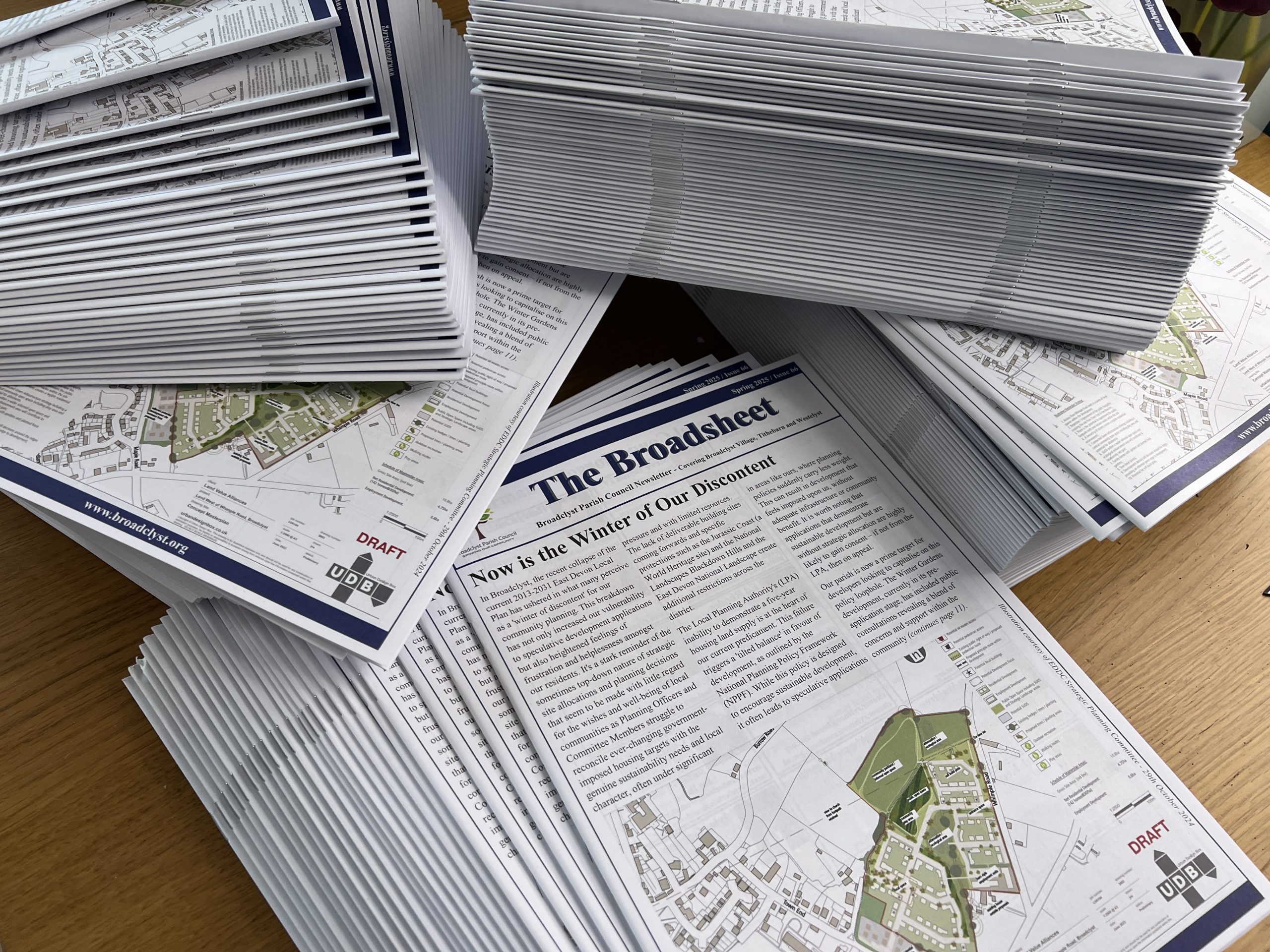 Photo of several piles of Broadsheet newsletters ready for delivery.